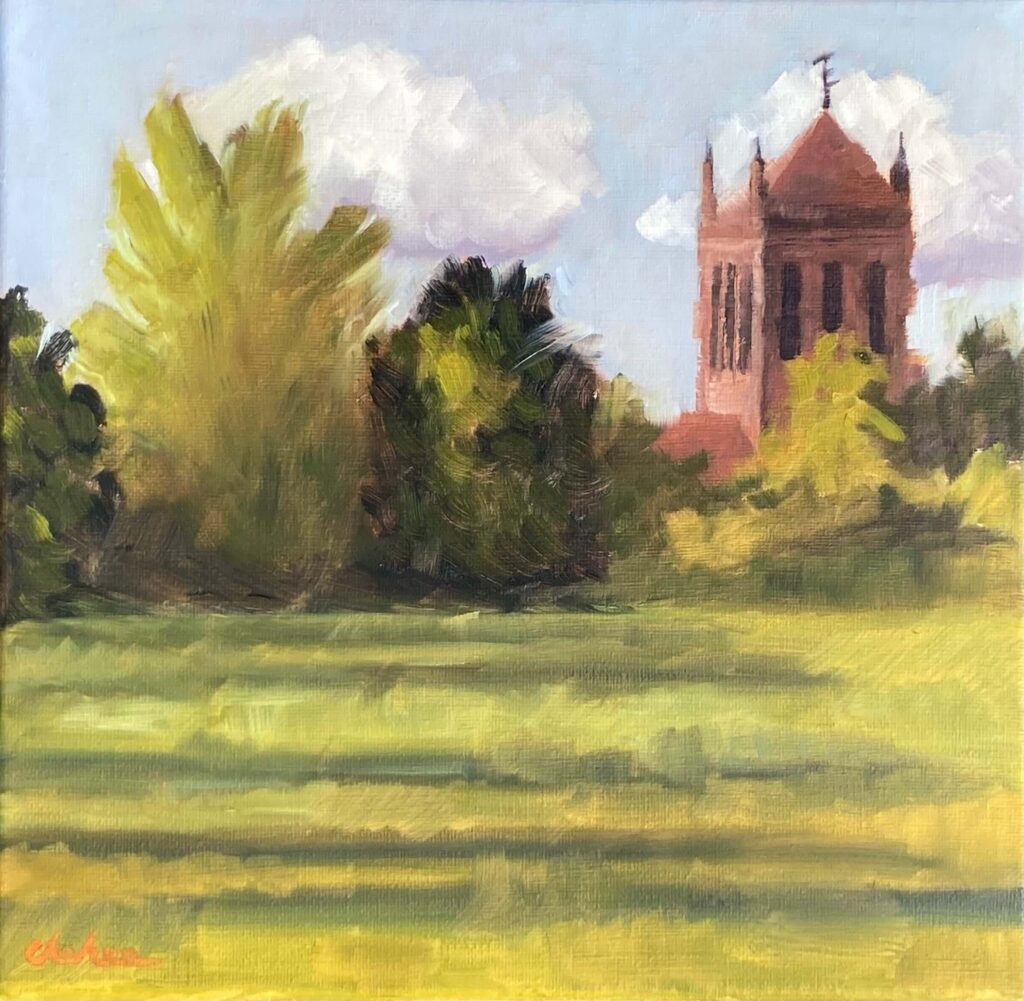 Plein air oil painting of Mossley Hill parish church rising above green trees and a sunlit field at Holt Field Liverpool
