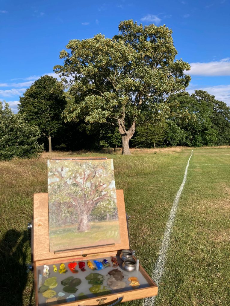 Oil painting of an oak tree in progress on a pochade box outdoors